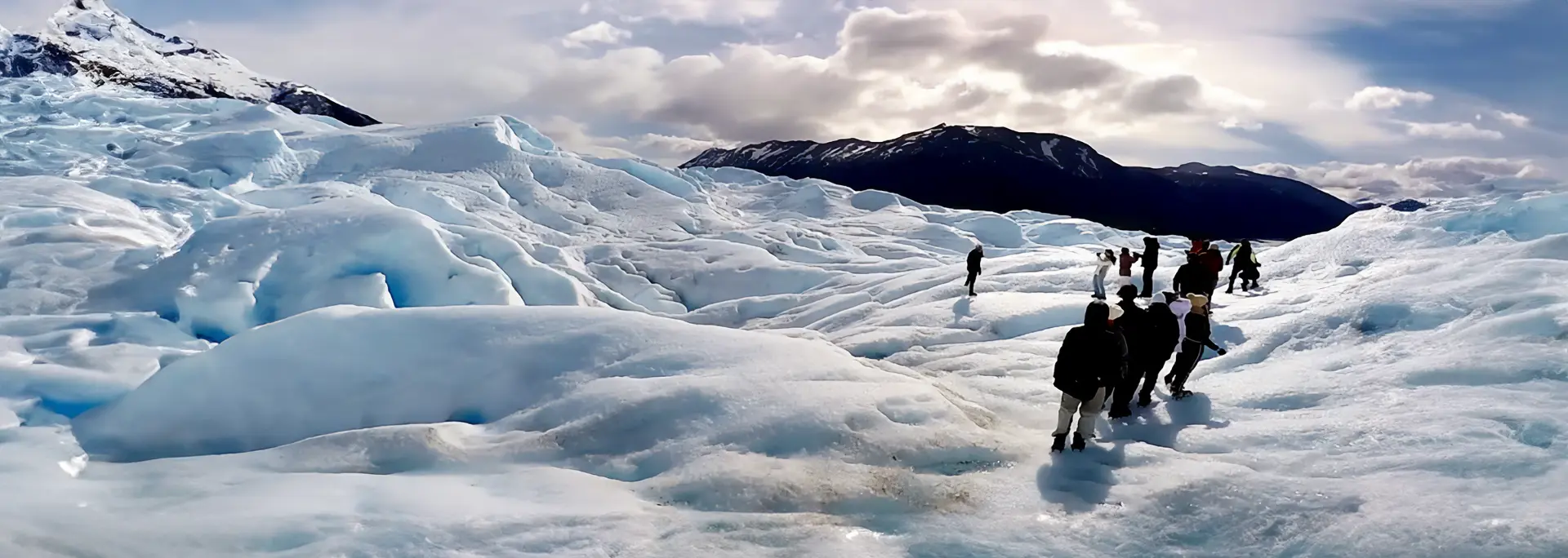 Grupo de aventureros con grampones realizando la excursión Minitrekking sobre la superficie azulada del Glaciar Perito Moreno en El Calafate.
