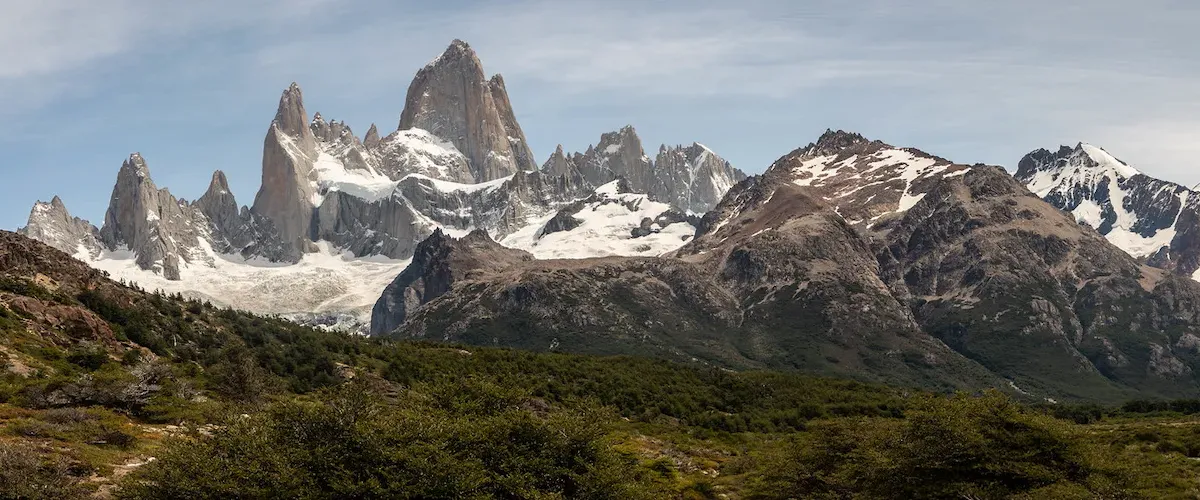 Vista del Monte Fitz Roy con picos nevados y cielo azul desde el sendero en El Chaltén